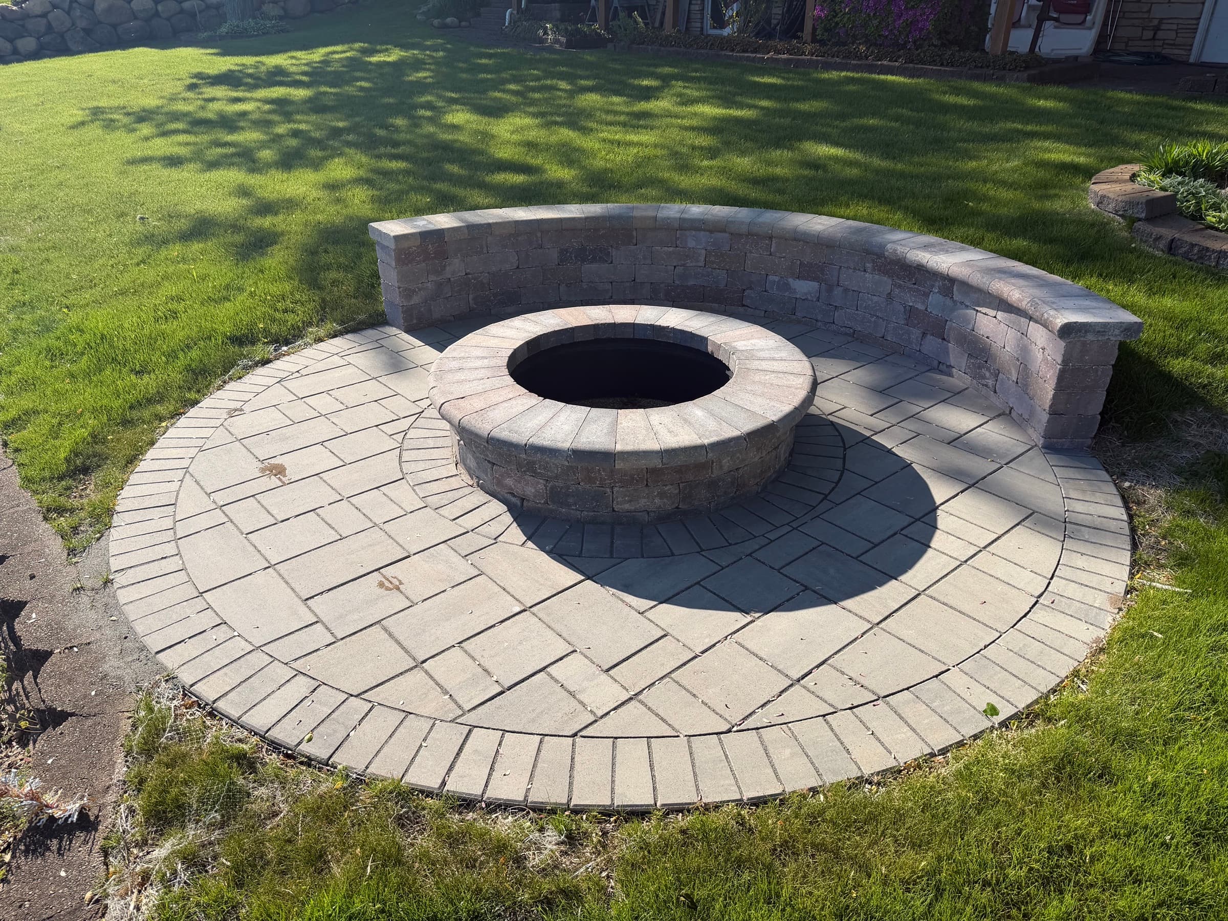 Circular paver patio with stone fire pit and curved seating wall, Southwest Michigan