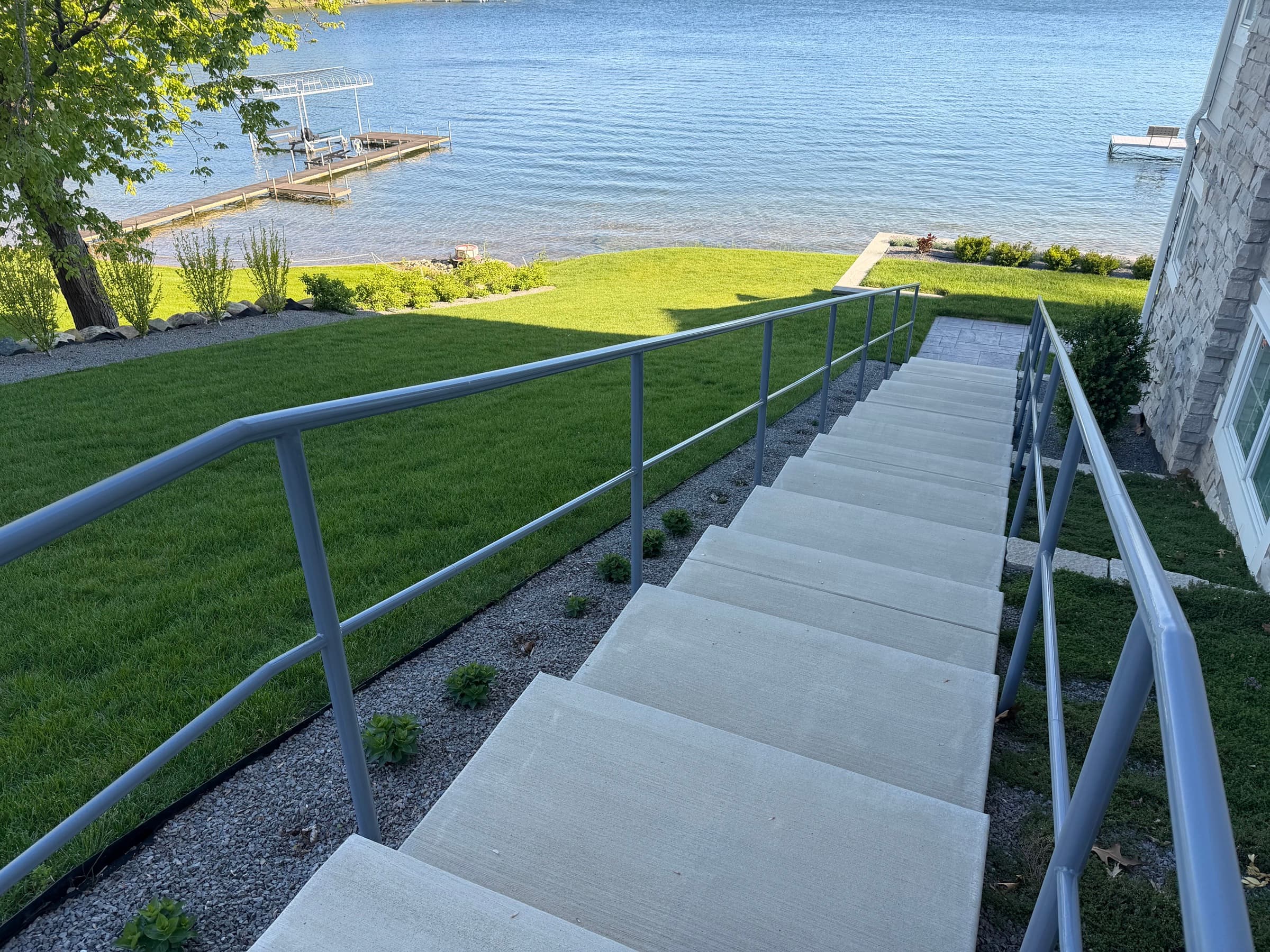 Concrete steps with metal railing leading to a Southwest Michigan lakefront