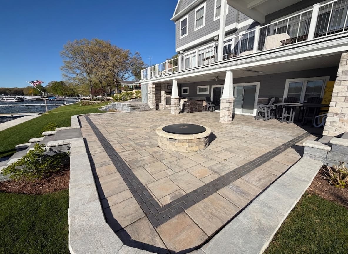 Large paver patio with stone fire pit at a Southwest Michigan lakefront property