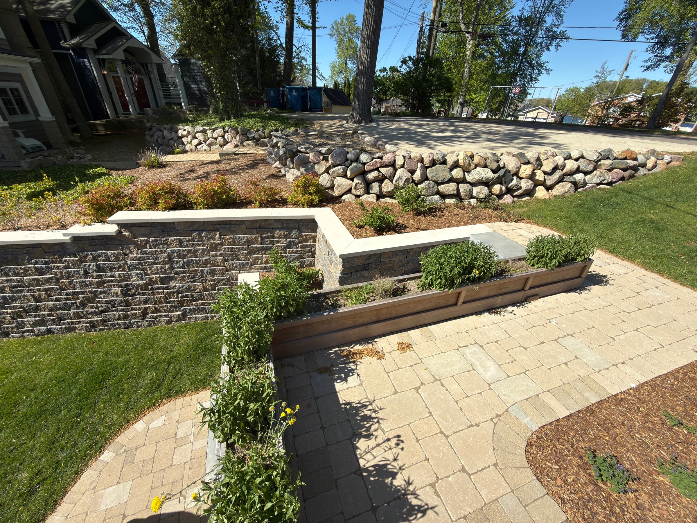 Layered retaining walls with planted beds and arborvitae, Southwest Michigan